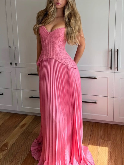 Pink corset maxi dress with lace bodice and pleated skirt worn indoors, front view