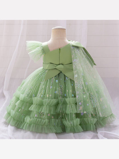 Back view of the green toddler princess dress on a mannequin: back zipper, back bow and sheer heart-print tulle drape from the shoulder