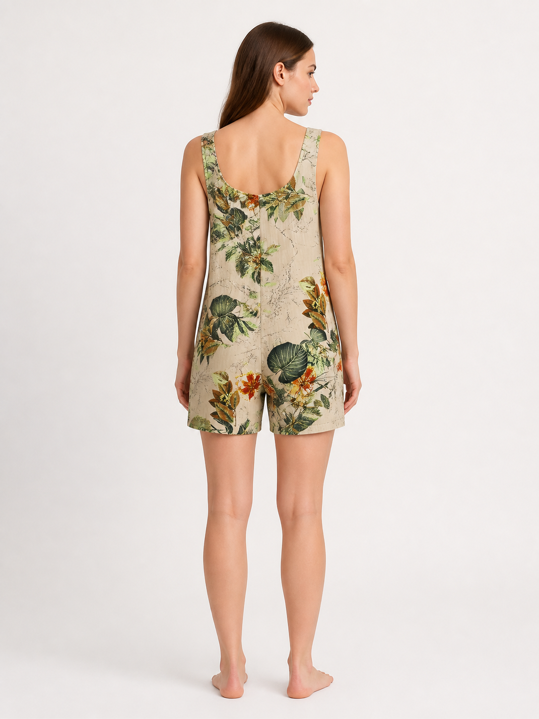 Back view of a beige floral romper showing shoulder straps, a square back neckline, and short legs