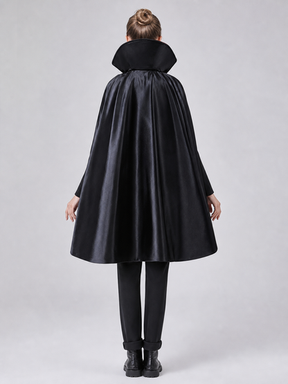 The long black cape is designed to create a vampire look for cosplay, Halloween, and stage performances. The cape is black and features a loose silhouette with long, draping panels and an opening lower edge. The upper section has a hooded o