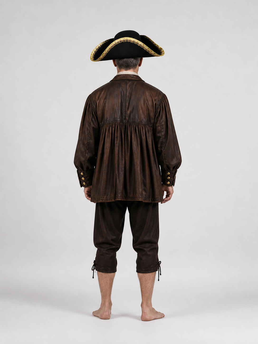 Black tricorn hat with gold trim worn by a barefoot model shown from the back in a brown costume