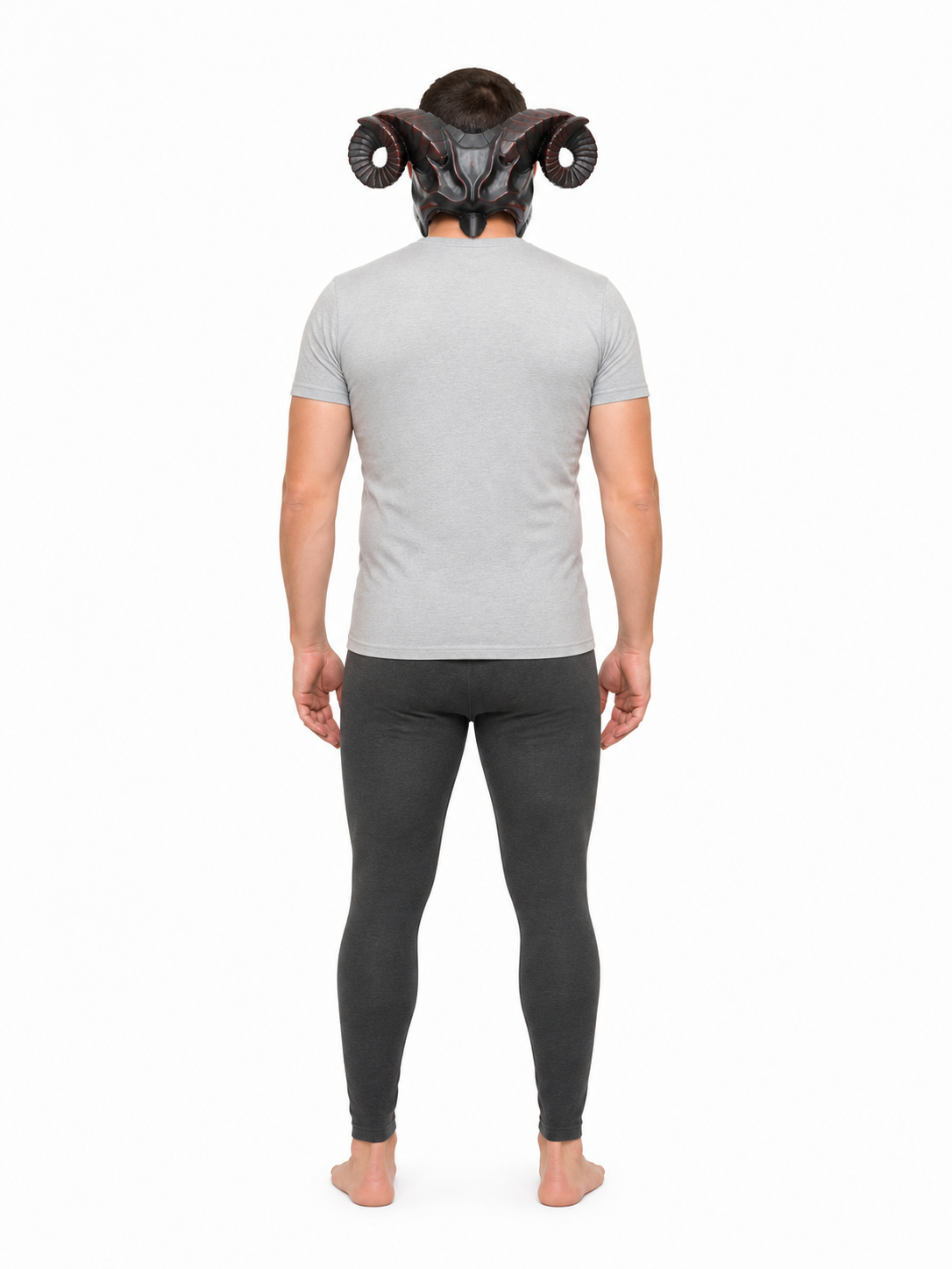 Full-body rear view of a man wearing the horned mask with curled ridged horns, a gray shirt, and dark leggings