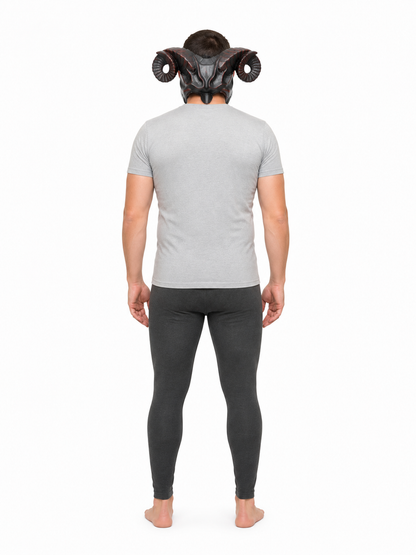 Full-body rear view of a man wearing the horned mask with curled ridged horns, a gray shirt, and dark leggings