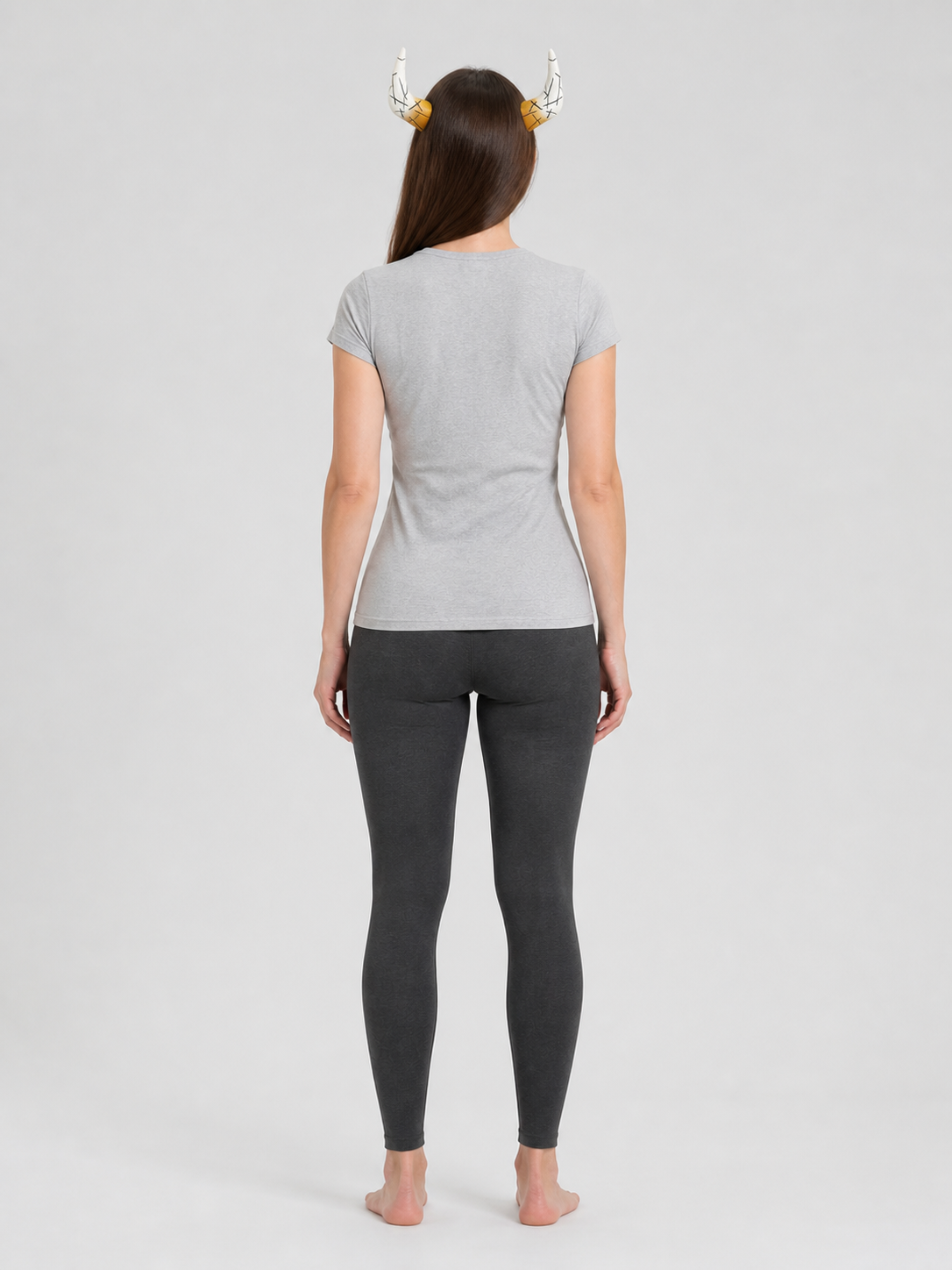 White and amber horn headpiece shown from behind on a model wearing a gray shirt and dark leggings