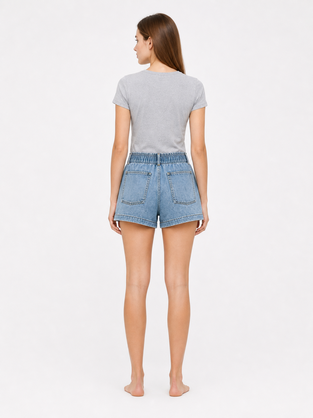 Light blue denim shorts shown from the back on a model, with two rear patch pockets and an elastic waistband