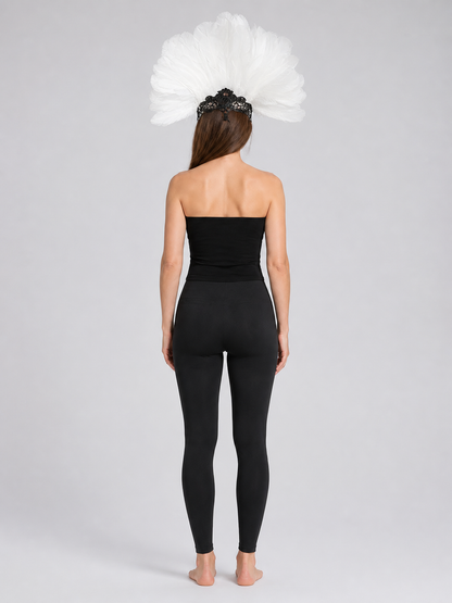 Back view of a model wearing the white feather headpiece with a black lace mask and a black fitted outfit