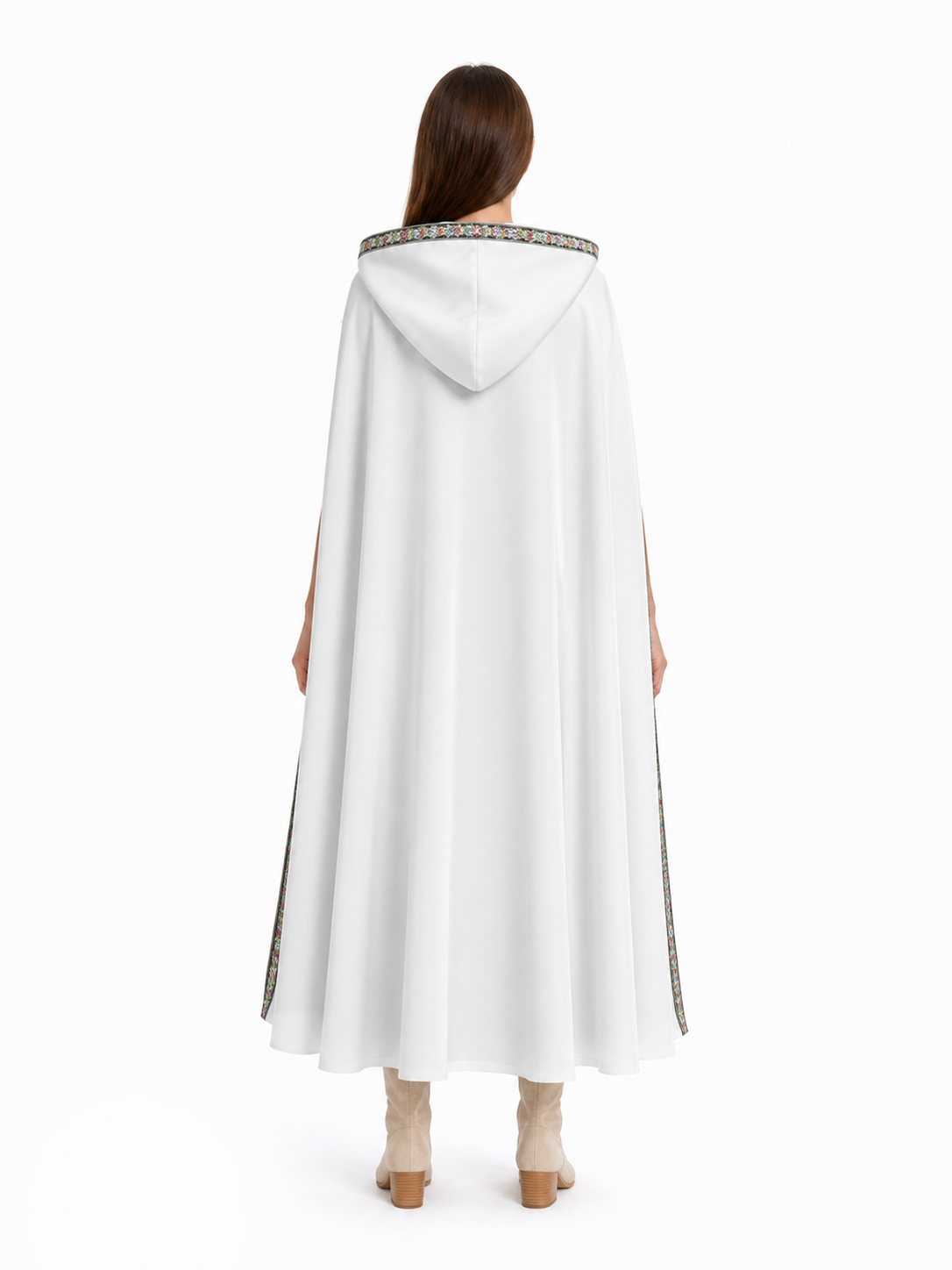 White hooded cape shown from the back on a model, with a plain flowing body and patterned trim around the hood and edges