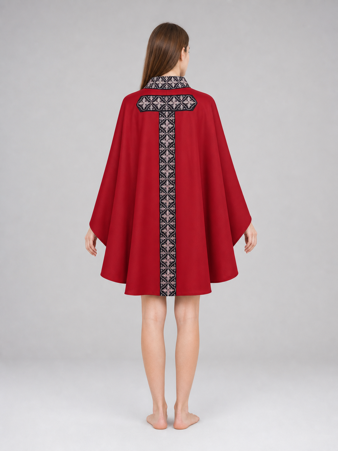 The cape is red with black decorative elements. It has a loose cloak-style silhouette, wide sleeves, and a collar with black patterned detailing. The front features a vertical decorative stripe down the center and a horizontal stripe across