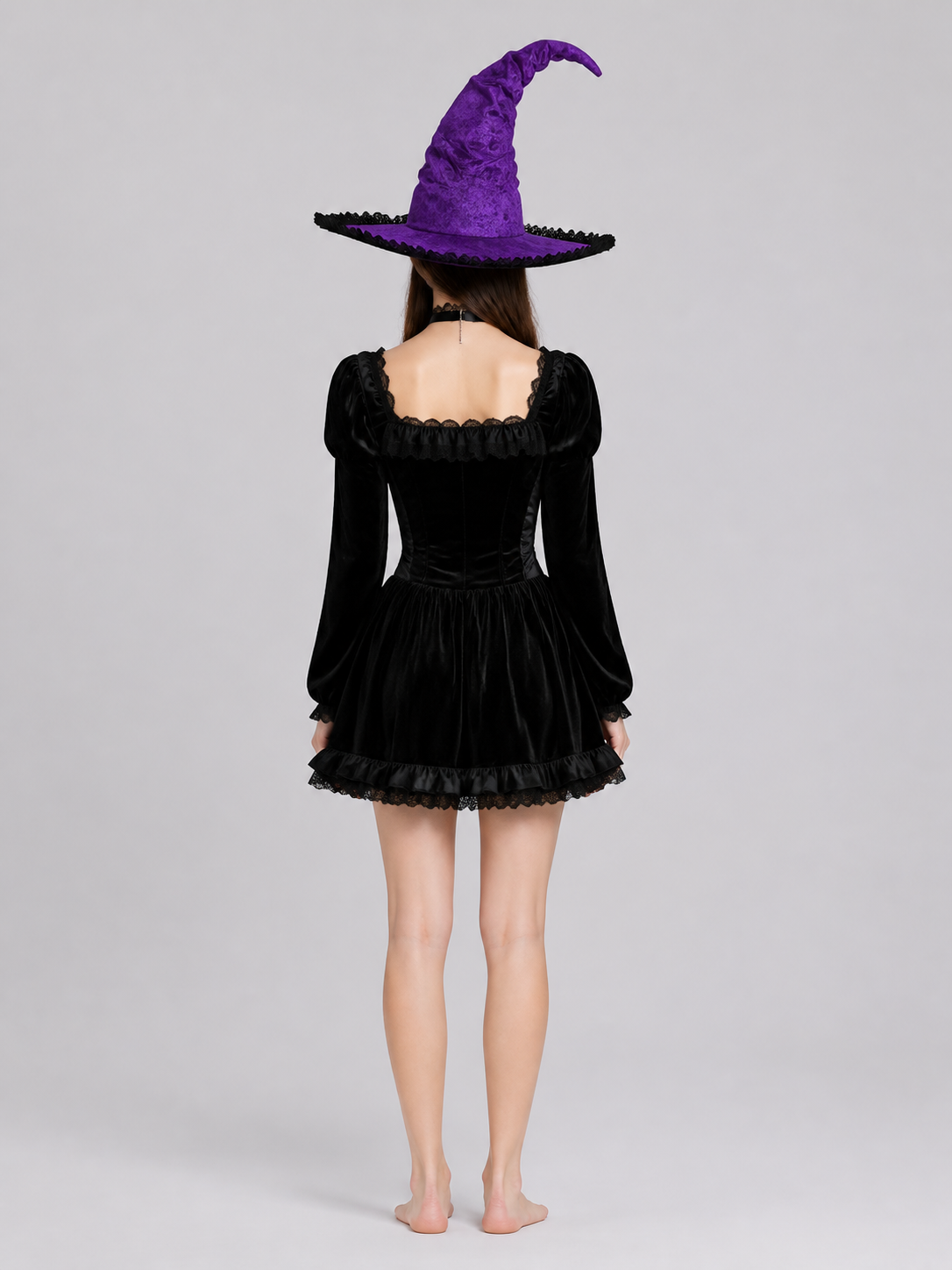 Back view of a model wearing a purple pointed witch hat with a wide brim and black trim, shown against a plain gray background