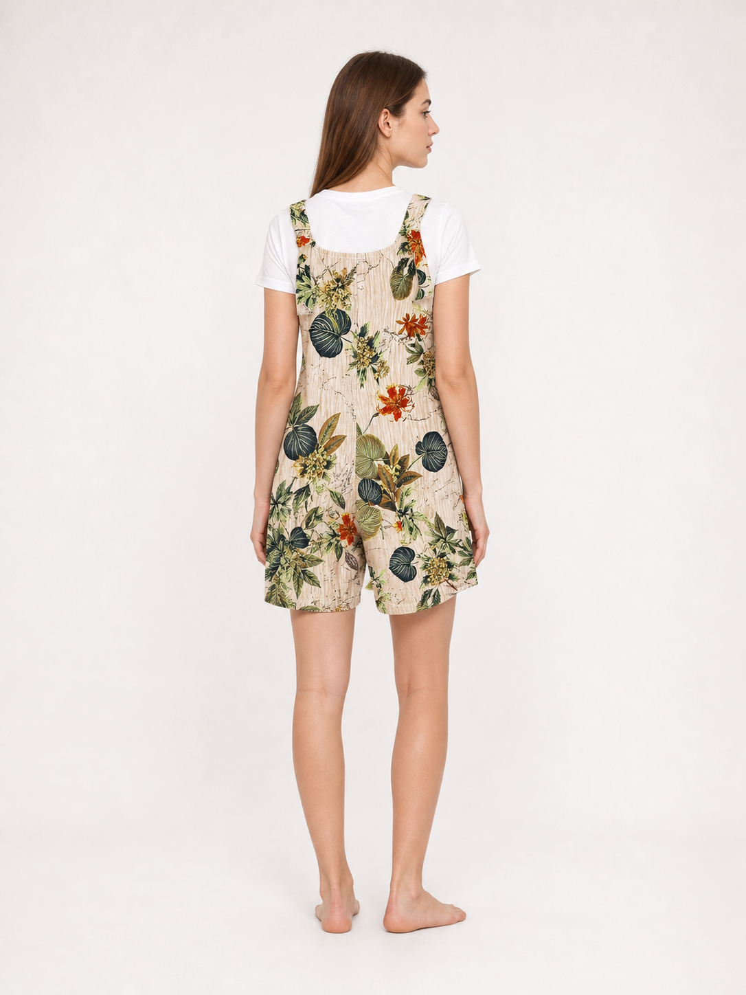 Back view of a beige floral romper layered over a white T-shirt, showing the floral print and square neckline