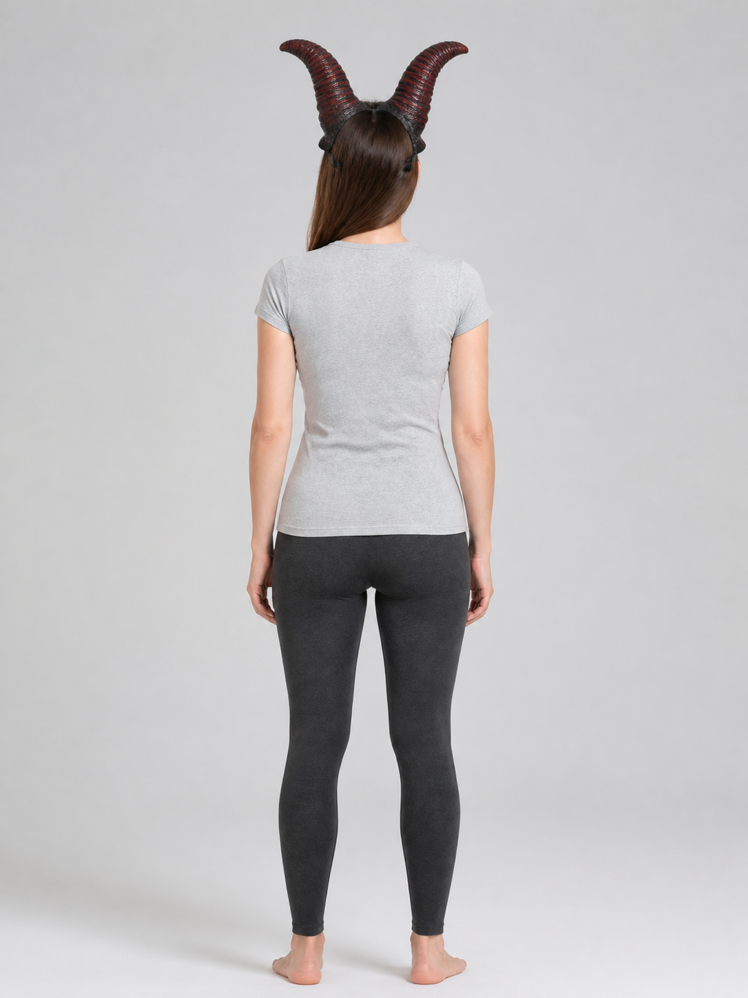 Red and black horn headband shown from the back on a full-body model wearing a gray shirt and black leggings
