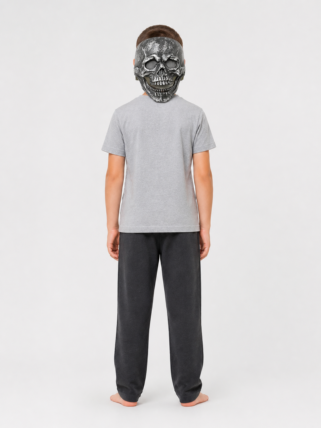 Black skull face mask with molded teeth and textured surface, shown on a full-body model viewed from the back