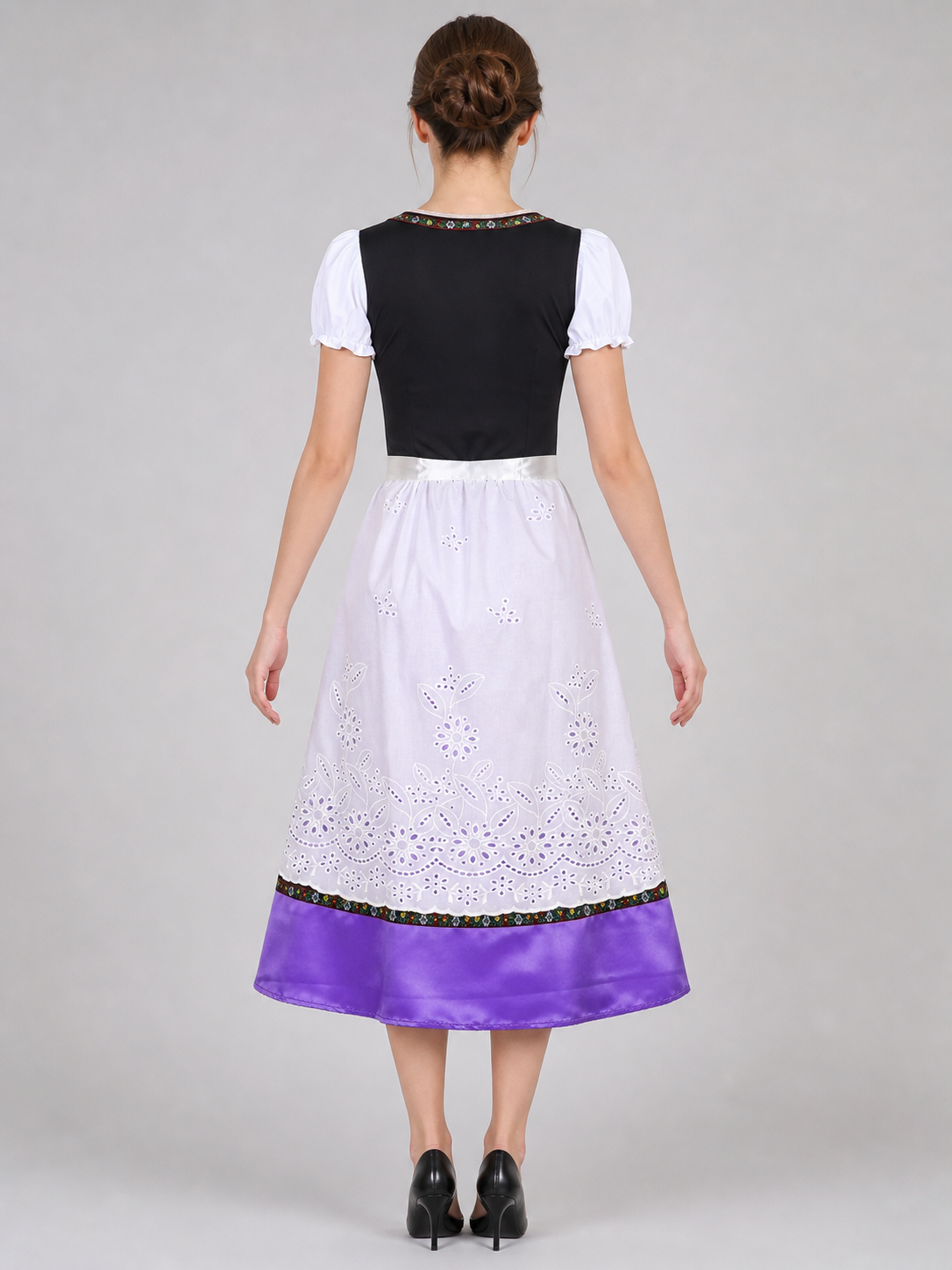 The dress is designed in an ethnic style and features a contrasting combination of white, pink, purple, and black. It has a black bodice, voluminous white puff sleeves, and a white waistband. The front is decorated with a purple lace-up det