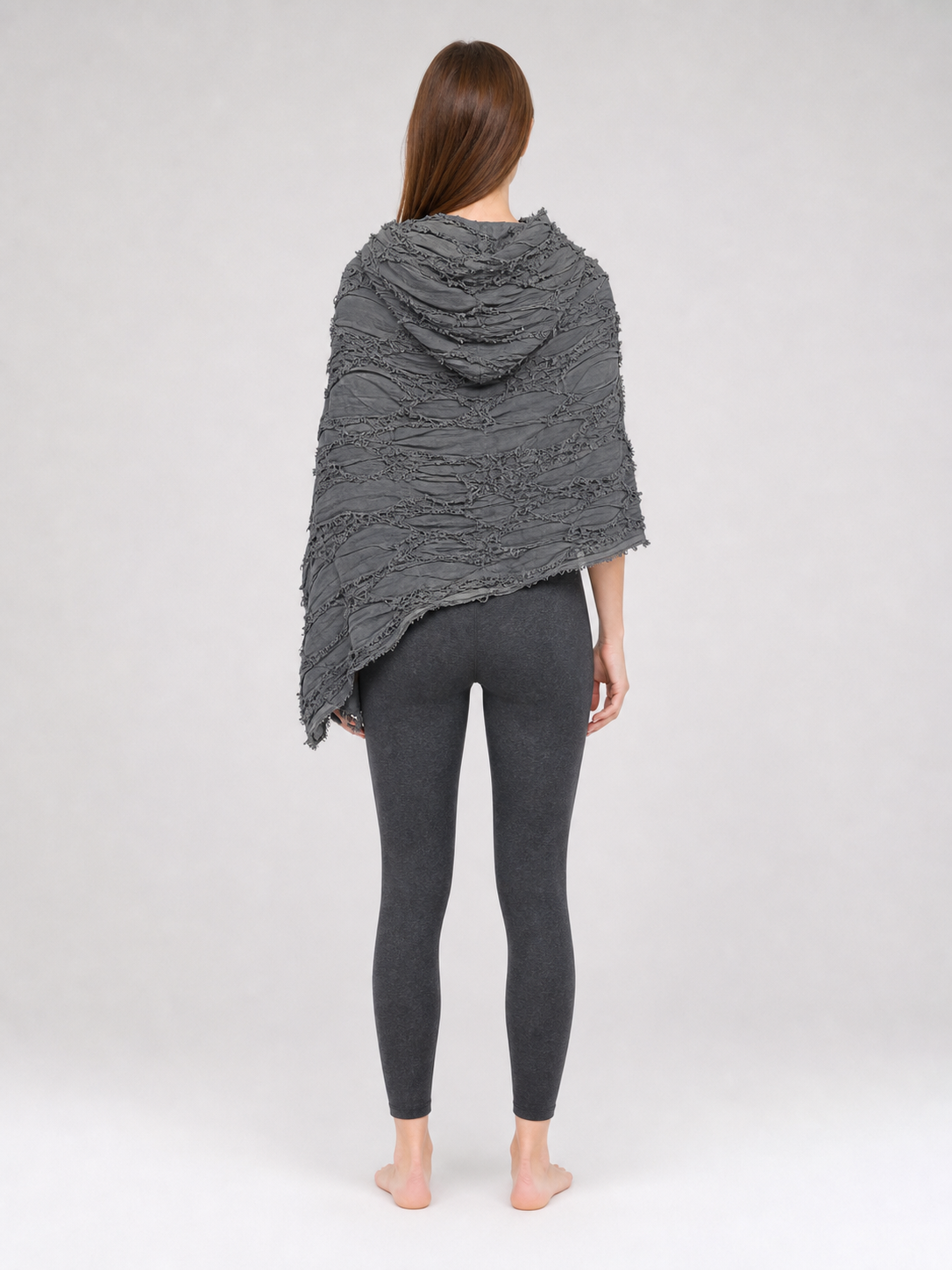 This large scarf-wrap is designed as a rectangular drape with a striking textured surface. The black-and-gray color palette is accented with lighter gray tones, giving the piece a distinctive look that pairs easily with different outfits. T