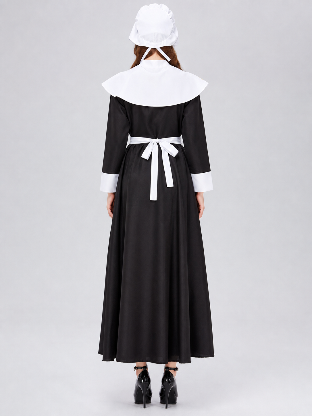 The uniform costume is designed in a black-and-white color scheme and combines elements of a classic maid outfit with a stage costume format. The model creates a complete look with a black top and skirt, long sleeves, white cuffs, a wide wh