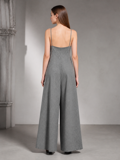 Back view of a gray wide-leg jumpsuit on a model, showing thin shoulder straps, a fitted upper back, and wide legs