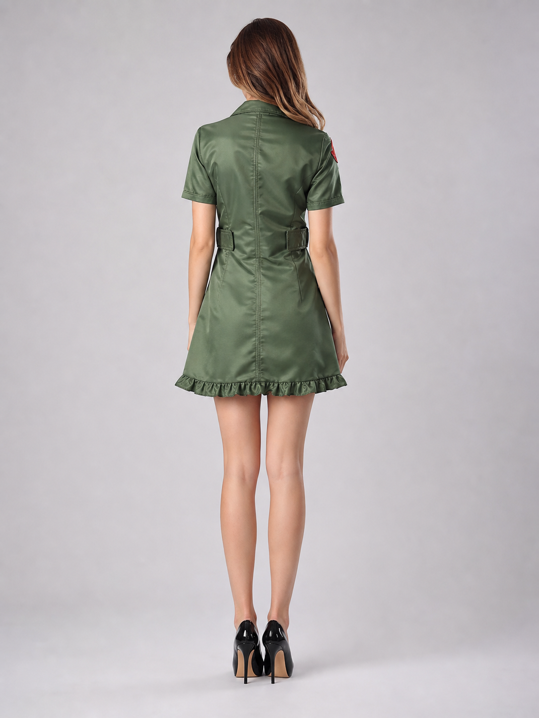 The uniform dress is made in military green and styled after professional aviation uniforms. The design is a short fitted dress with short sleeves, a notched collar, and a front zipper. Aviation-themed patches and insignia, as well as a pat
