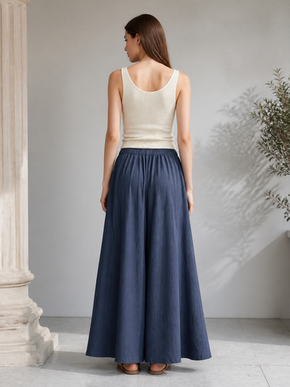 Back view of dark blue wide leg pants with an elastic waistband, styled with a white sleeveless top