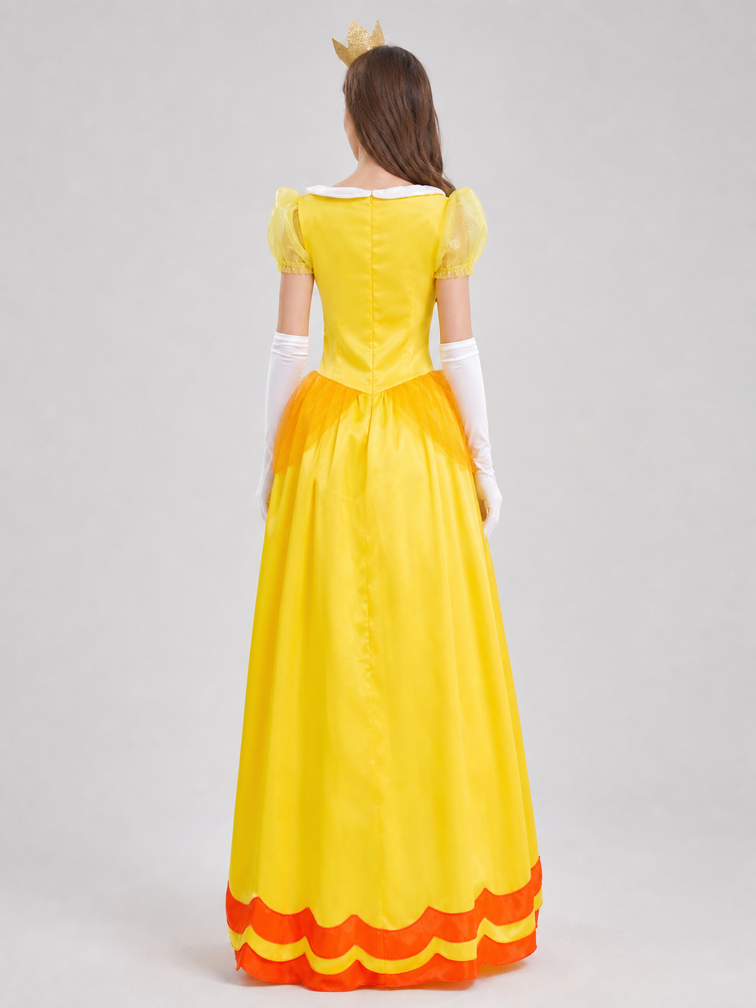 The princess costume features a festive style with distinctive details. The look is centered around a yellow dress with a fitted bodice and full skirt. Symmetrical orange decorative lines on the chest accent the bodice design. A white colla