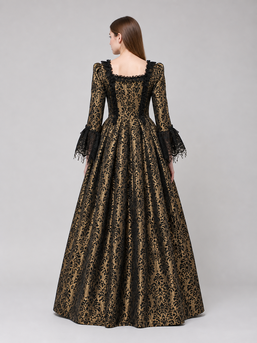 The dress is designed in a historical style with theatrical and decorative details. A golden-beige center is paired with black outer panels and damask-patterned trim, creating a striking contrast. The fitted bodice is decorated with visible
