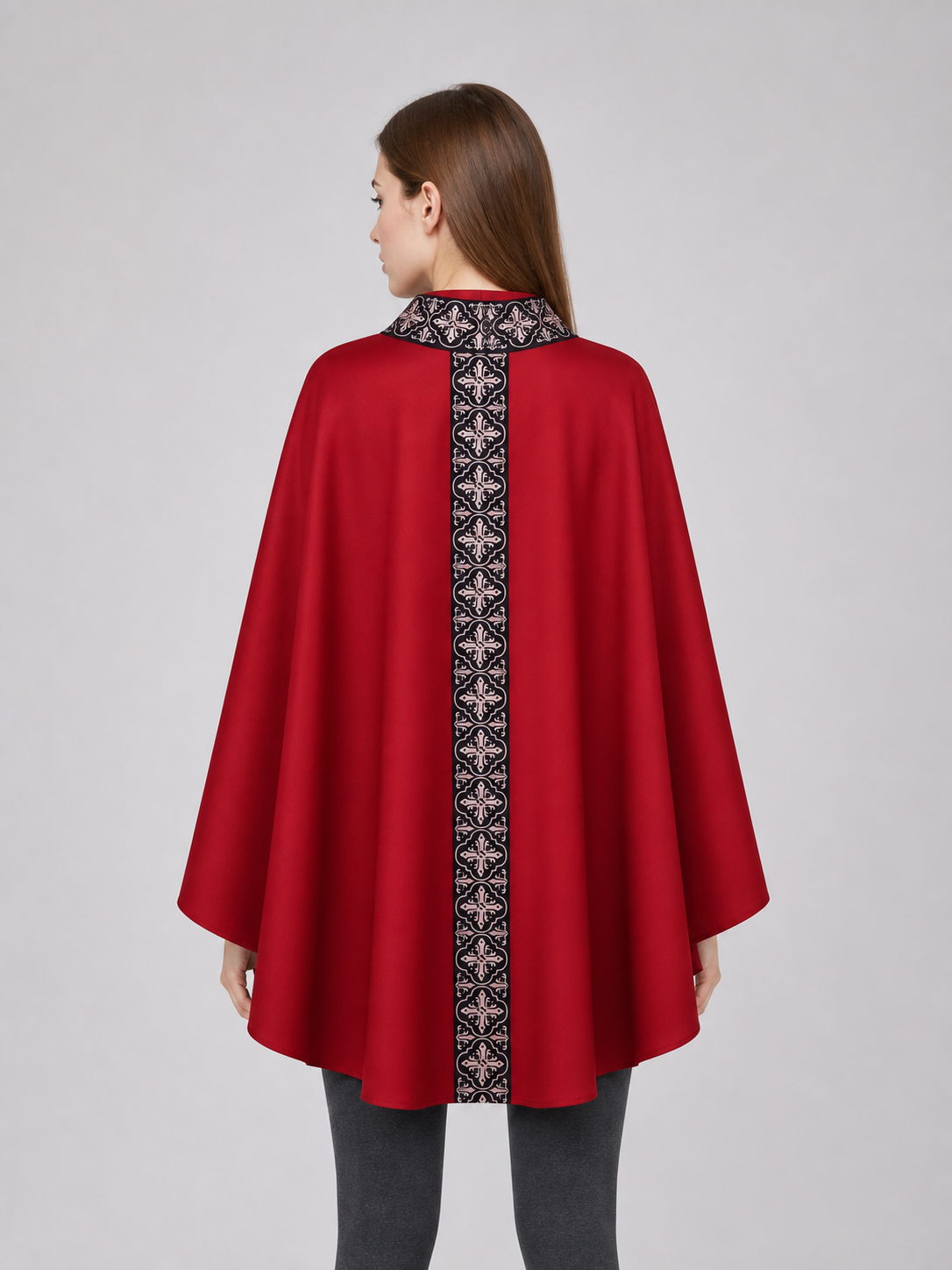 The cape is red with black decorative elements. It has a loose cloak-style silhouette, wide sleeves, and a collar with black patterned detailing. The front features a vertical decorative stripe down the center and a horizontal stripe across