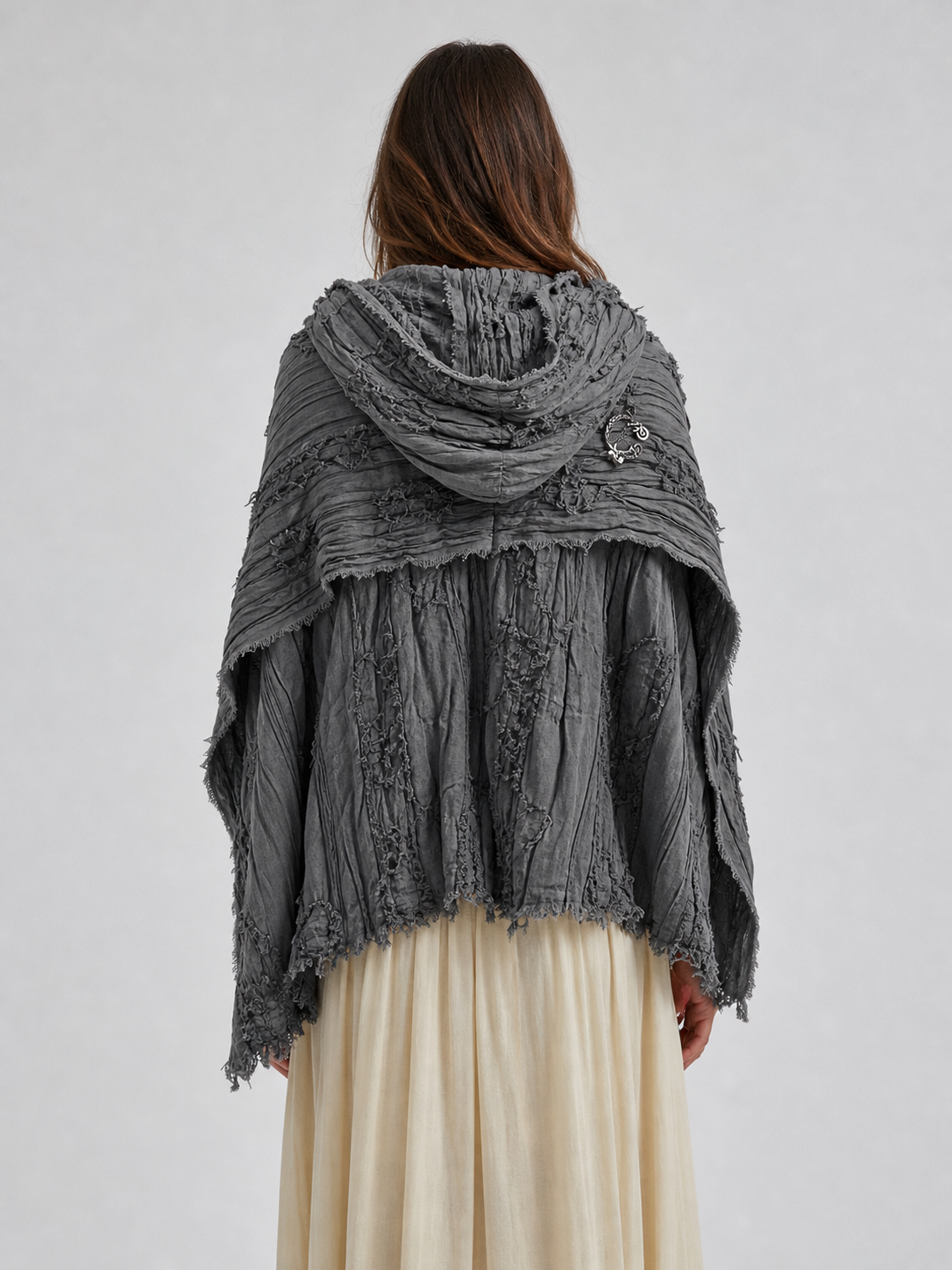 This large scarf-wrap is designed as a rectangular drape with a striking textured surface. The black-and-gray color palette is accented with lighter gray tones, giving the piece a distinctive look that pairs easily with different outfits. T
