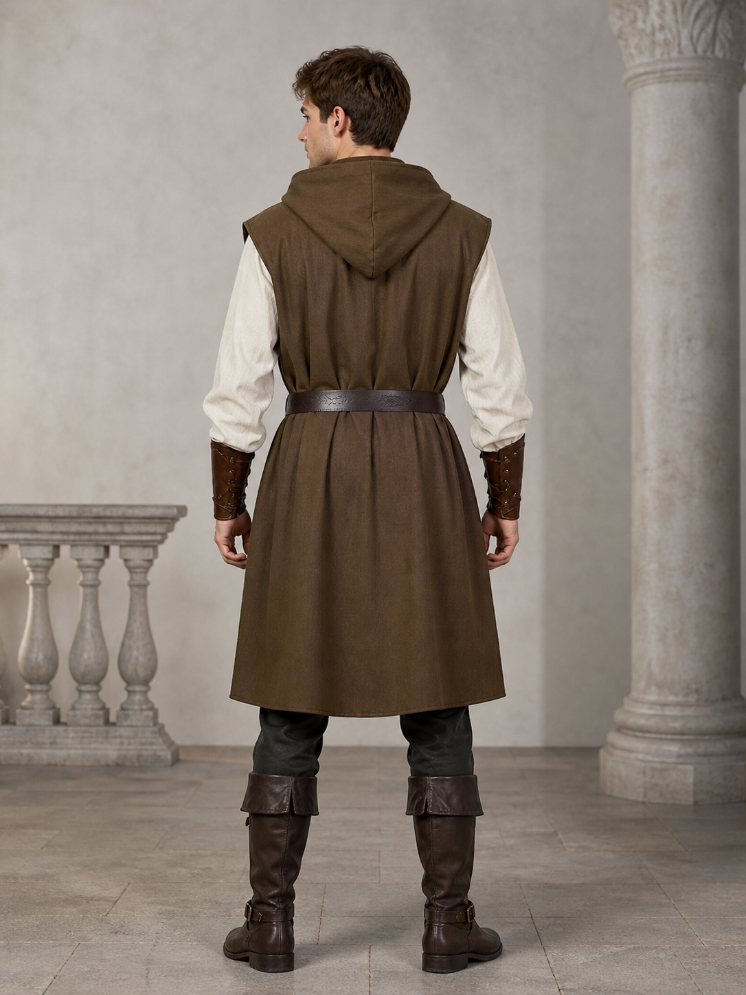 Back view of a brown sleeveless hooded vest with a dark waist belt on a male model in a stone interior