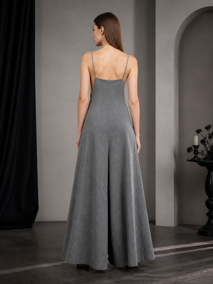 Back view of a gray wide-leg jumpsuit with thin straps and wide legs, shown on a model against a dark neutral background