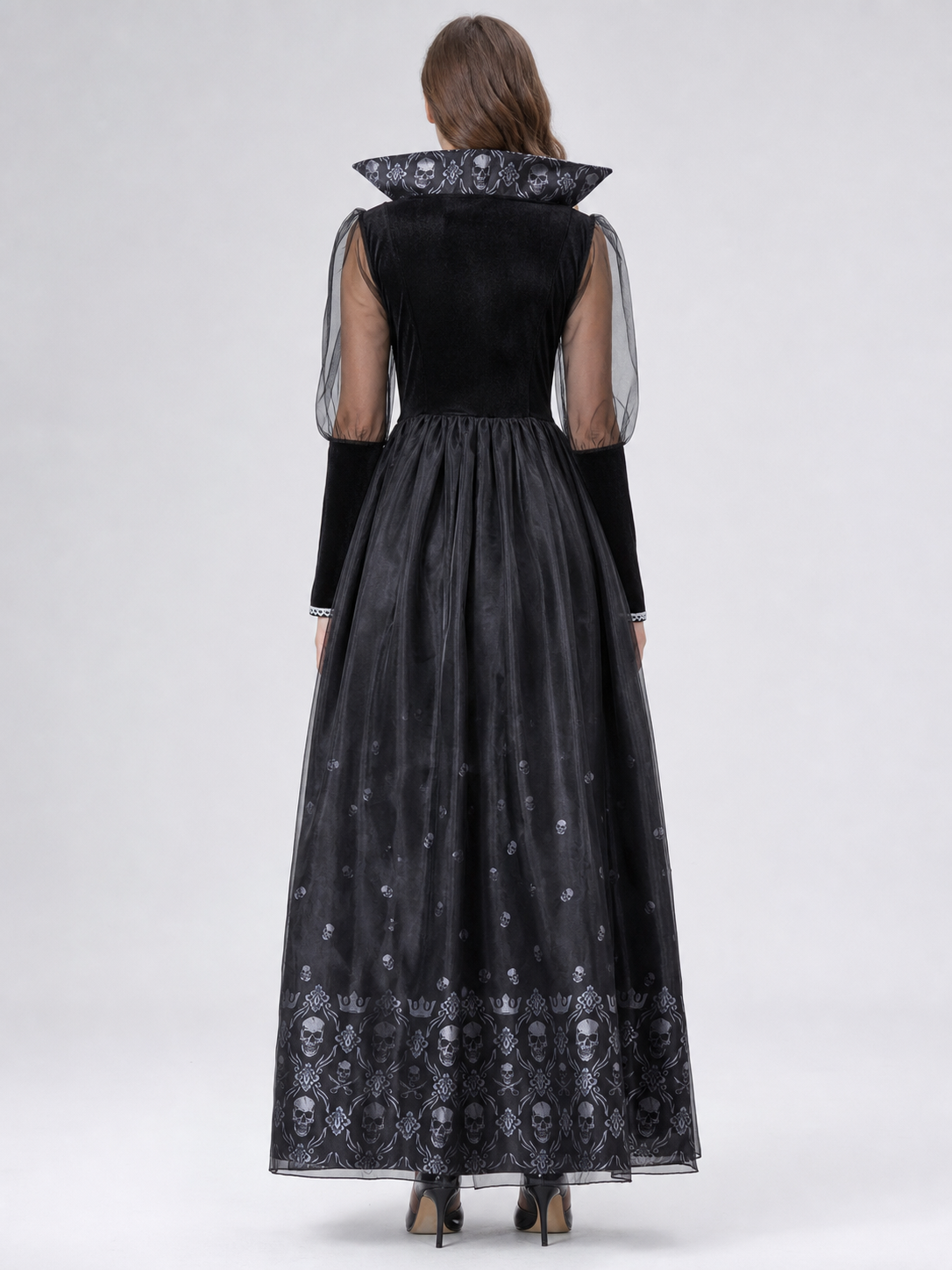 Black gothic-style dress with silver-white decorative skull motifs. The design features a long silhouette with sheer mesh sleeves and an accent neckline with a pointed shape. Silver decorative trim is placed across the chest, complementing 