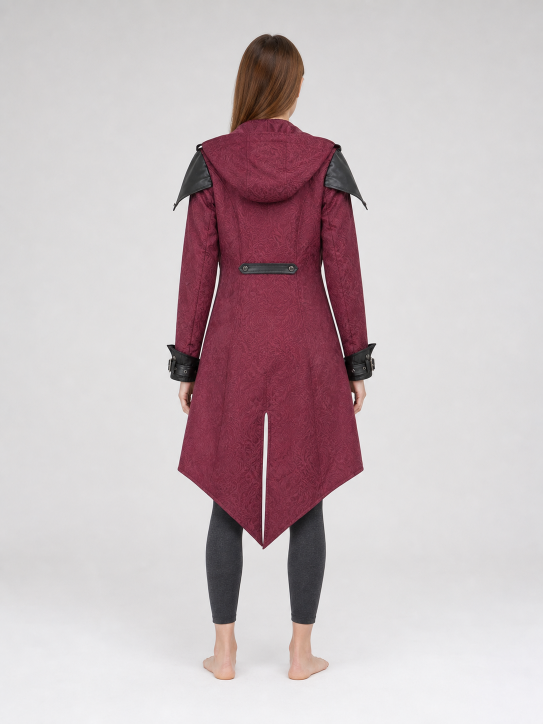 Black long gothic fantasy-style coat with decorative details, a high collar, and an asymmetrical pointed hem. The design features long sleeves and a front zipper closure. Decorative buckle straps are positioned at the waist and cuffs, while