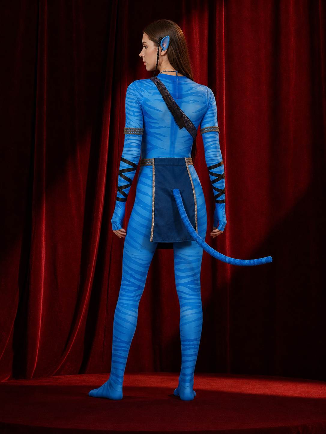 Back view of the blue striped bodysuit showing the long tail, apron ties and shoulder strap