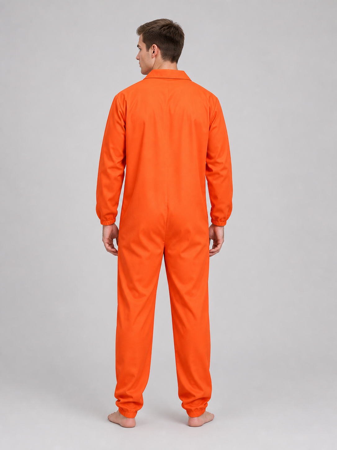 Orange coverall with a smooth fabric look, collar, long sleeves, and gathered cuffs, shown from the back on a model wearing black shoes