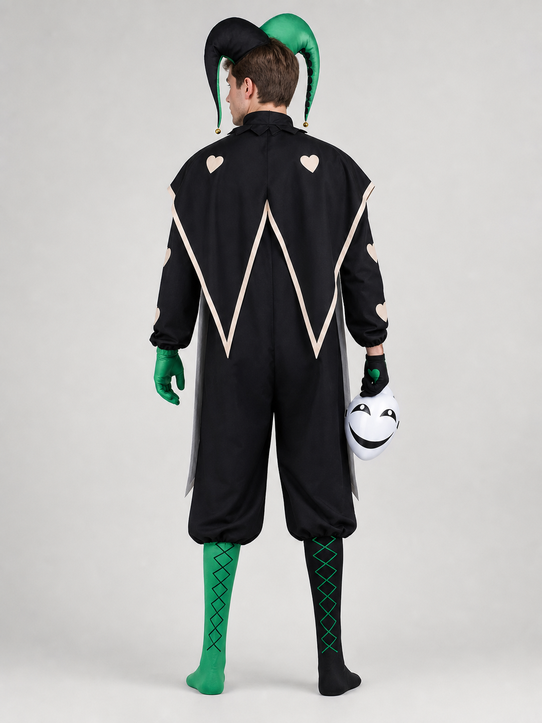 Back view of the black and green jester clown costume: pointed black cape with cream hearts, two-tone jester hat and green and black leg covers
