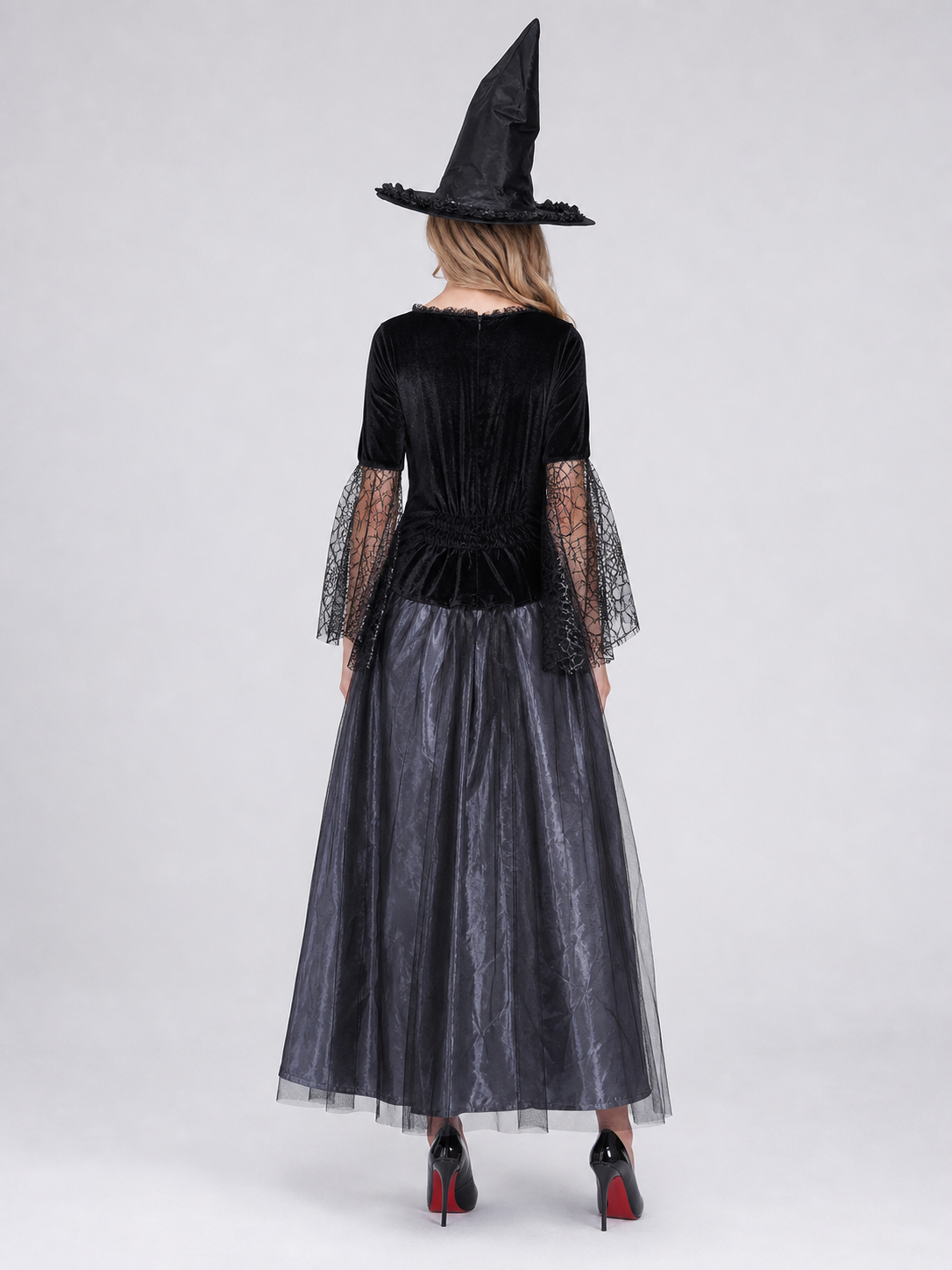 Gothic-style witch costume dress with hat for themed events. The design is mainly black and dark gray, with patterned textured fabric and sheer black accents. The look is centered on a long dress with a fitted lace-up corset, a ruffled neck