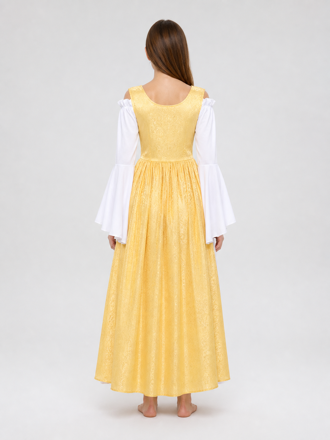 The yellow dress is designed in a fairytale costume style with expressive details inspired by medieval and Renaissance looks. It features a long, floor-length silhouette and a flared skirt paired with a fitted waistline. The front of the bo