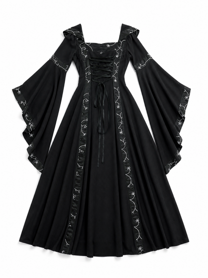 The dress is designed in a gothic style with elements of Victorian aesthetics. The model features a flared silhouette, a square neckline, and long sleeves with flared cuffs. The bodice is decorated with gathers that emphasize the garment’s 