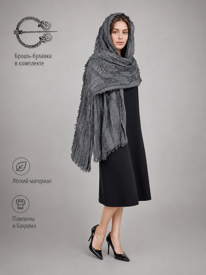This large scarf-wrap is designed as a rectangular drape with a striking textured surface. The black-and-gray color palette is accented with lighter gray tones, giving the piece a distinctive look that pairs easily with different outfits. T