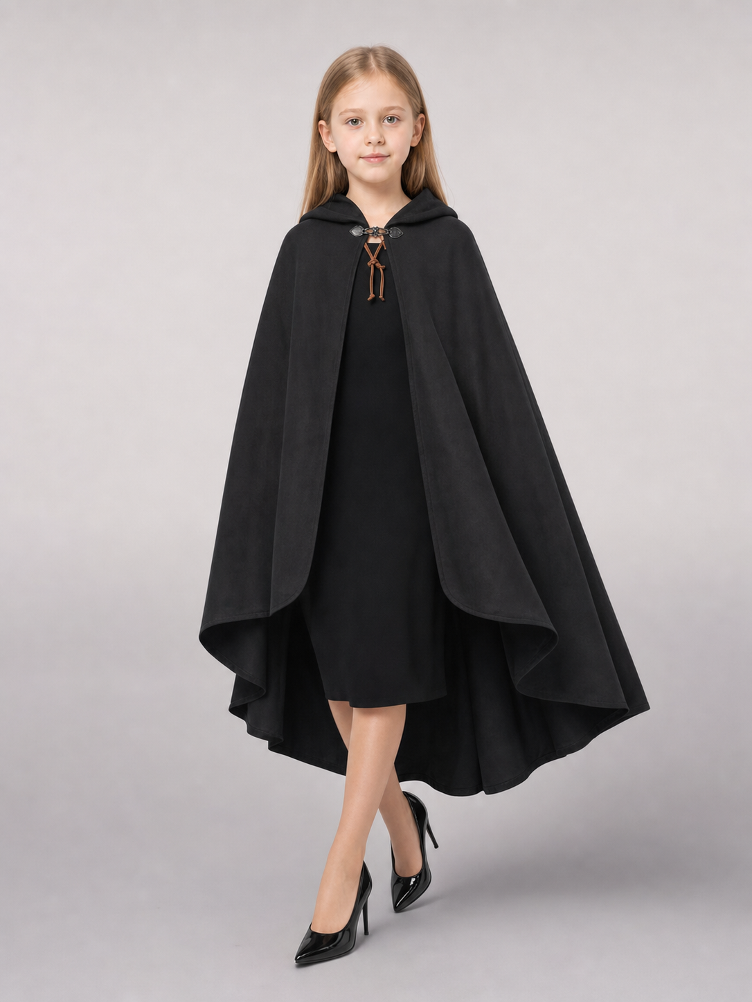 Black hooded cloak shown in a three-quarter view on a child over a black dress, with a brown lace closure
