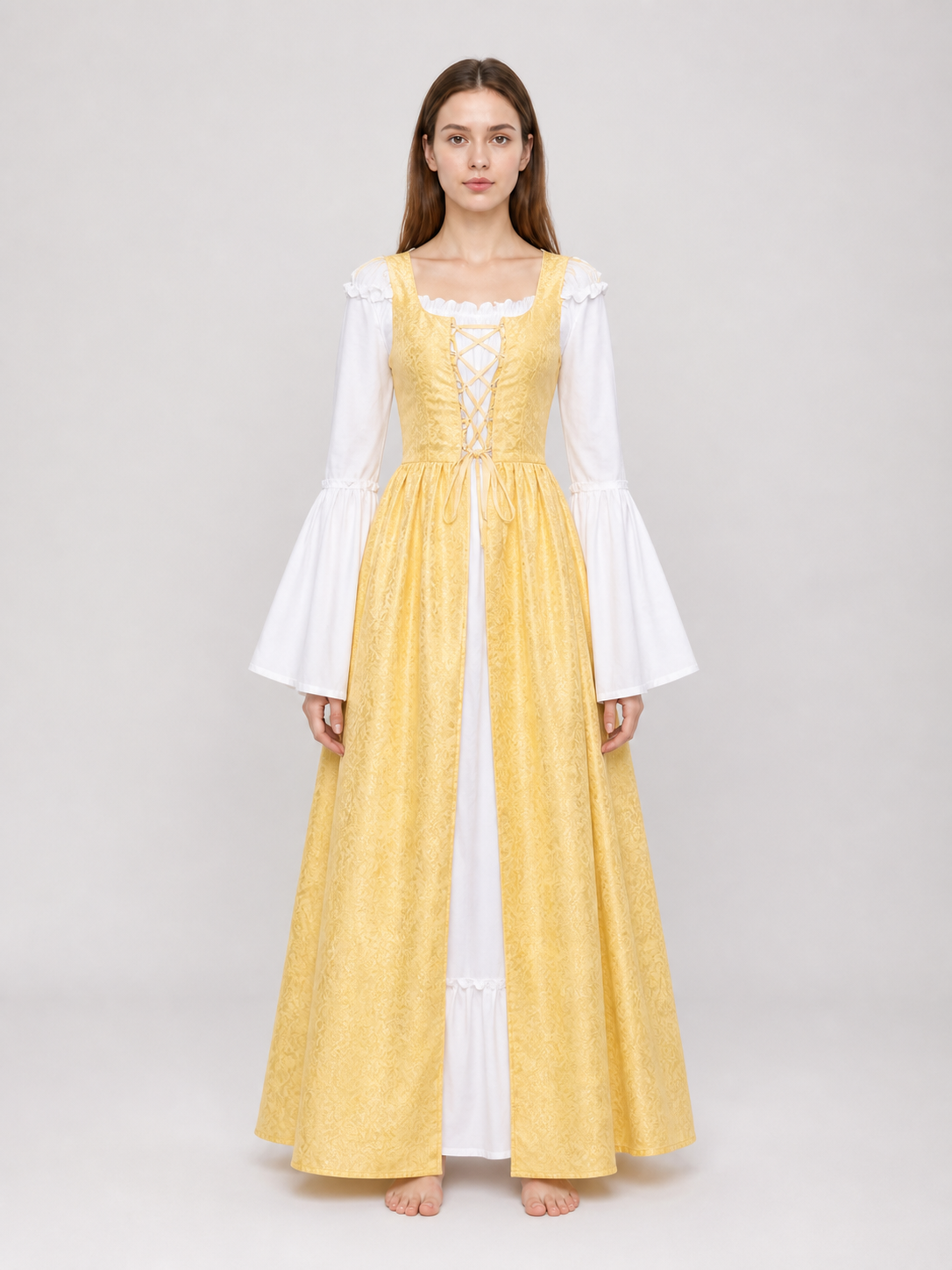 The yellow dress is designed in a fairytale costume style with expressive details inspired by medieval and Renaissance looks. It features a long, floor-length silhouette and a flared skirt paired with a fitted waistline. The front of the bo