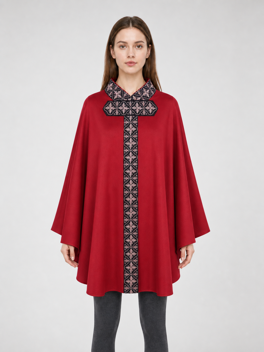 The cape is red with black decorative elements. It has a loose cloak-style silhouette, wide sleeves, and a collar with black patterned detailing. The front features a vertical decorative stripe down the center and a horizontal stripe across