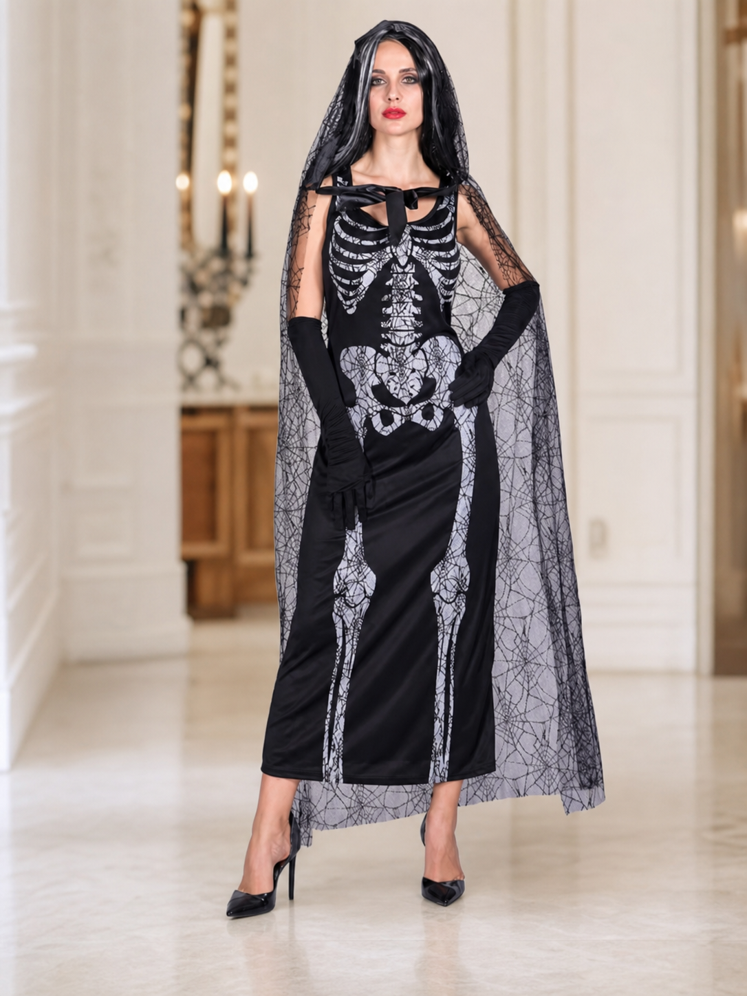 Gothic Halloween costume dress with accessories: a sleeveless black dress with a white rib and pelvic bone print, a sheer cape or veil with a spiderweb design, black gloves, and a necktie or bow detail. The look is done in black and white w