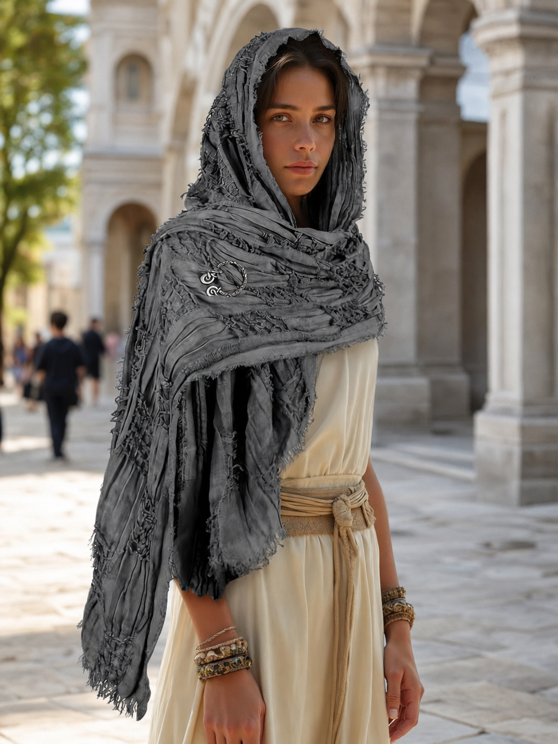 This large scarf-wrap is designed as a rectangular drape with a striking textured surface. The black-and-gray color palette is accented with lighter gray tones, giving the piece a distinctive look that pairs easily with different outfits. T