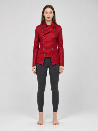 The jacket is presented in a vintage red color and designed in a military style with elements of Gothic aesthetics. The model features a distinctive front construction with a diagonal wrap, giving the garment a bold character. A double row 