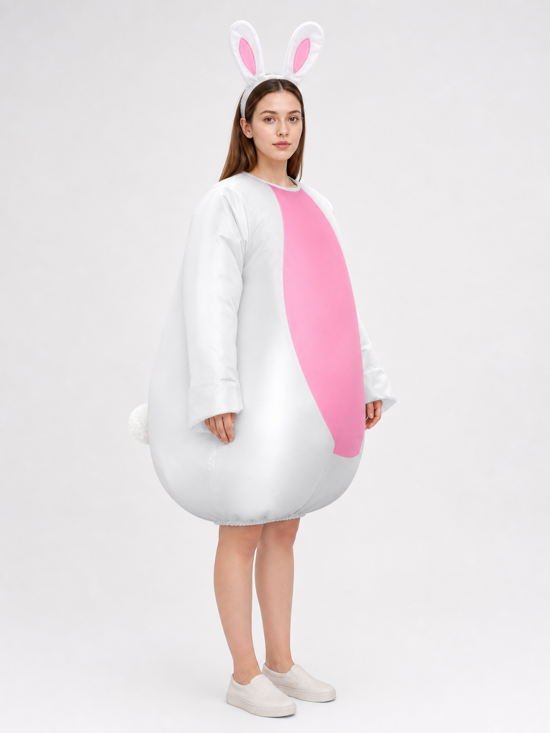 Three-quarter side view of a white and pink rabbit jumpsuit with bunny-ear headband, rounded hem, and visible rear pom-pom