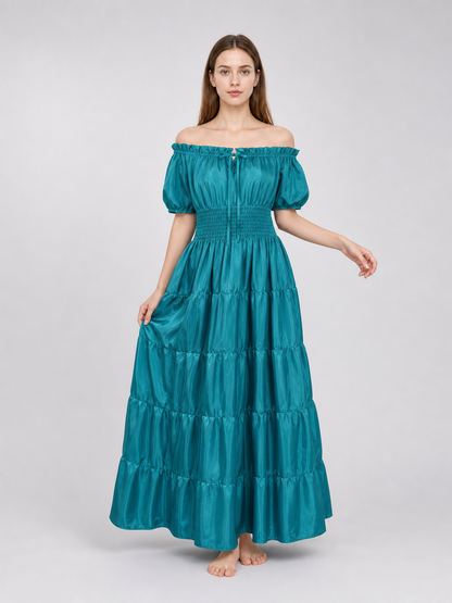 Teal satin-look dress shown full length on a model, with an off-shoulder neckline, short puff sleeves, smocked waist, and gathered tiered skirt