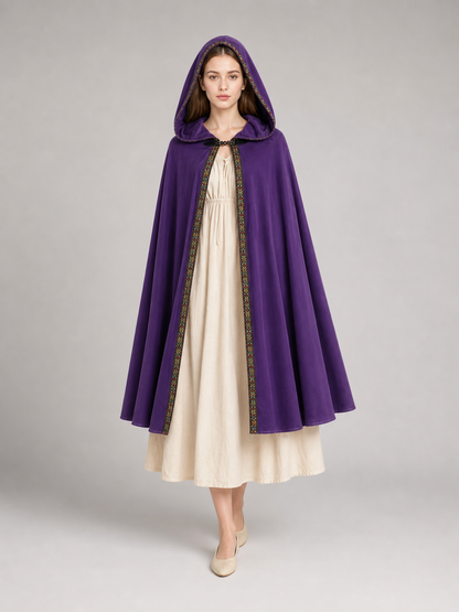 Purple hooded cape with patterned trim, shown on a model over a cream dress 2