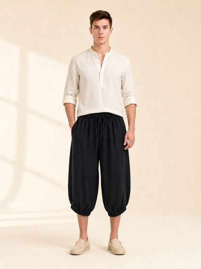 Black cropped pants with an elastic waist and loose legs, styled with a light shirt and slip-on shoes