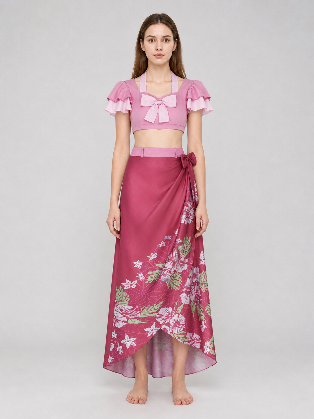 This cosplay set is designed as a short-sleeve crop top and a long skirt. It includes a top, a half-skirt, and decorative bows. There is a bow on the chest of the top, and another bow is placed on the side of the skirt waist. The top has an