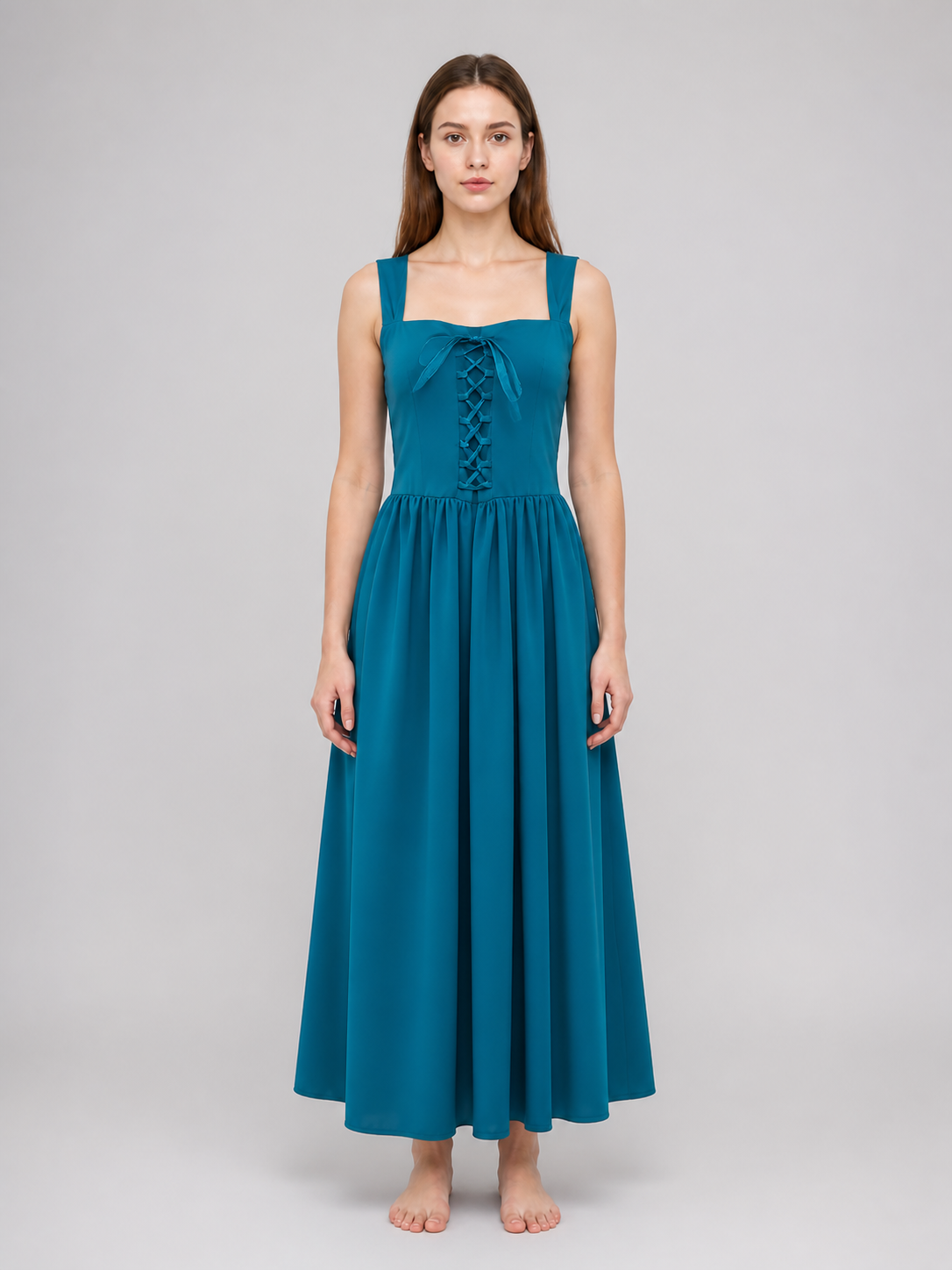Teal sleeveless dress with square neckline, front lace-up detail, gathered waist, and long flowing skirt shown from the front