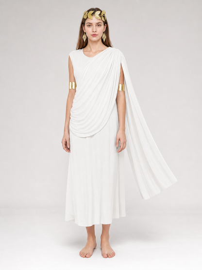 Full-body model wearing a white draped dress with a long train and gold arm bands, barefoot against a plain gray background